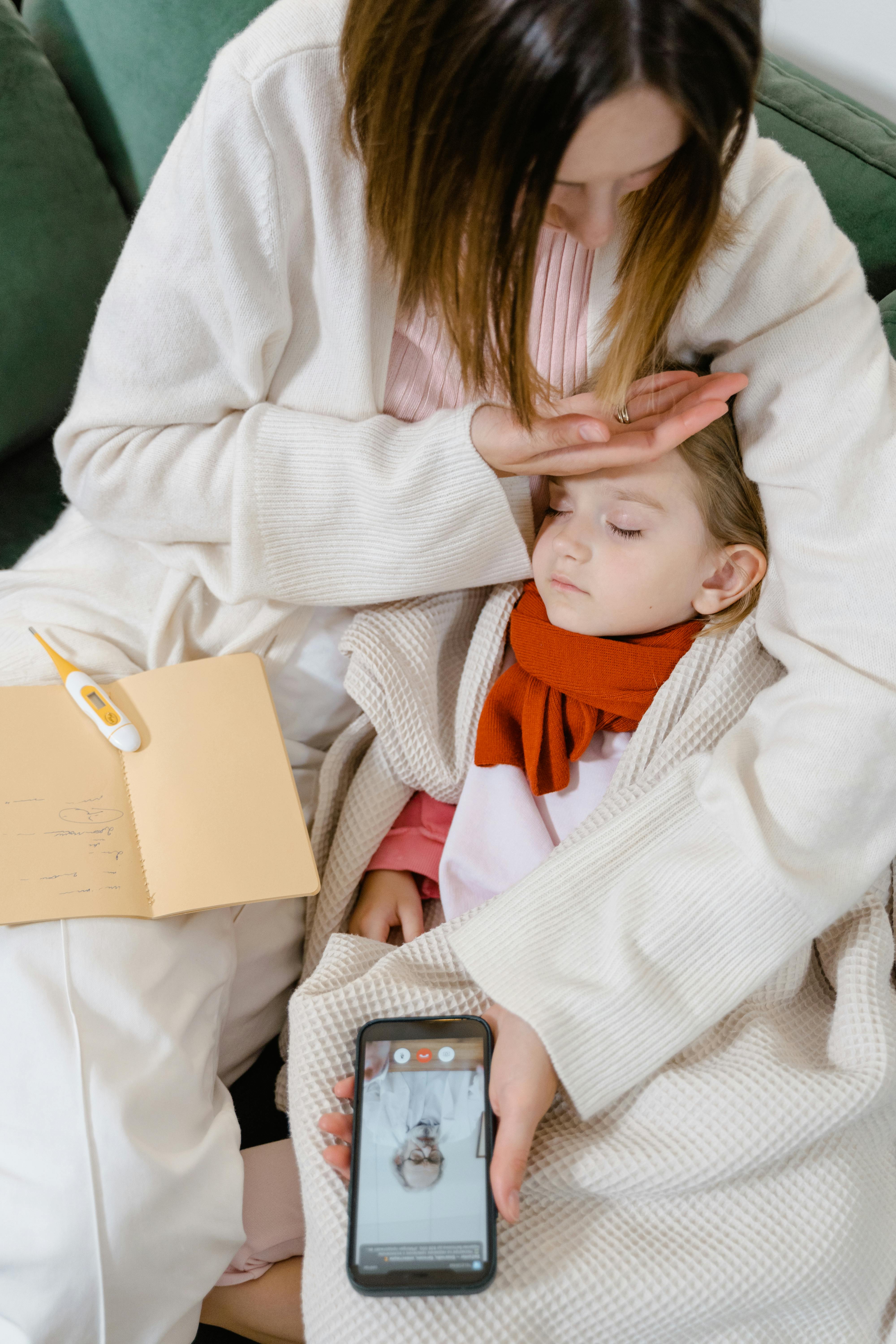 Mother using telemedicine to care for a sick child at home, combining health and comfort.